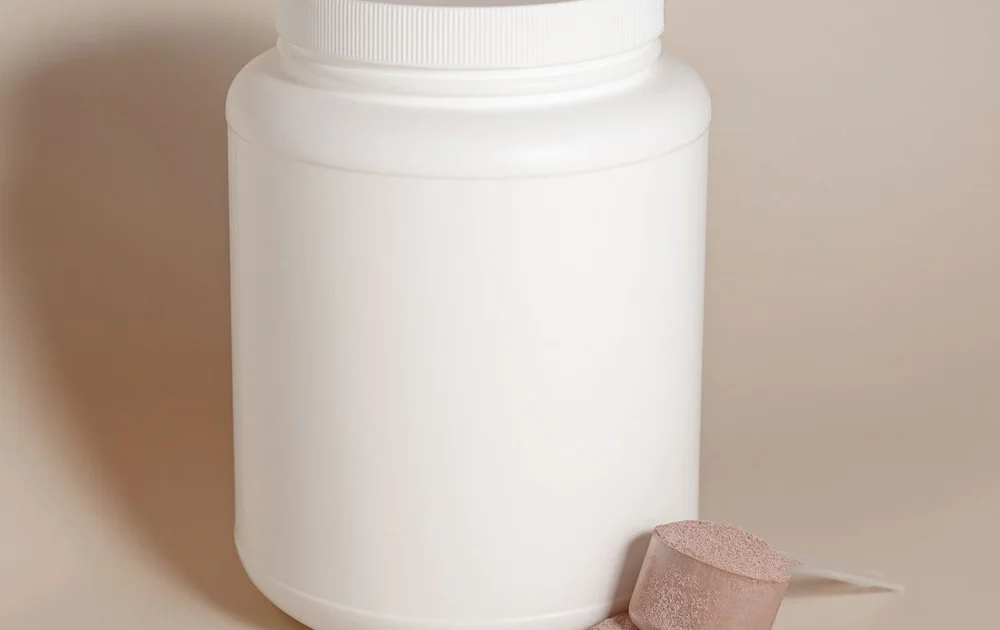 A scoop beside an unbranded supplement container